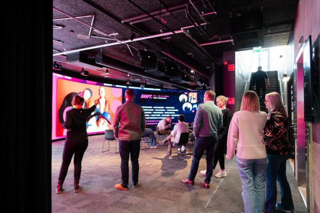 Ihmisiä Tapahtumatalo Joen Showroomissa katsomassa 22,5 metriä leveää led-seinää.