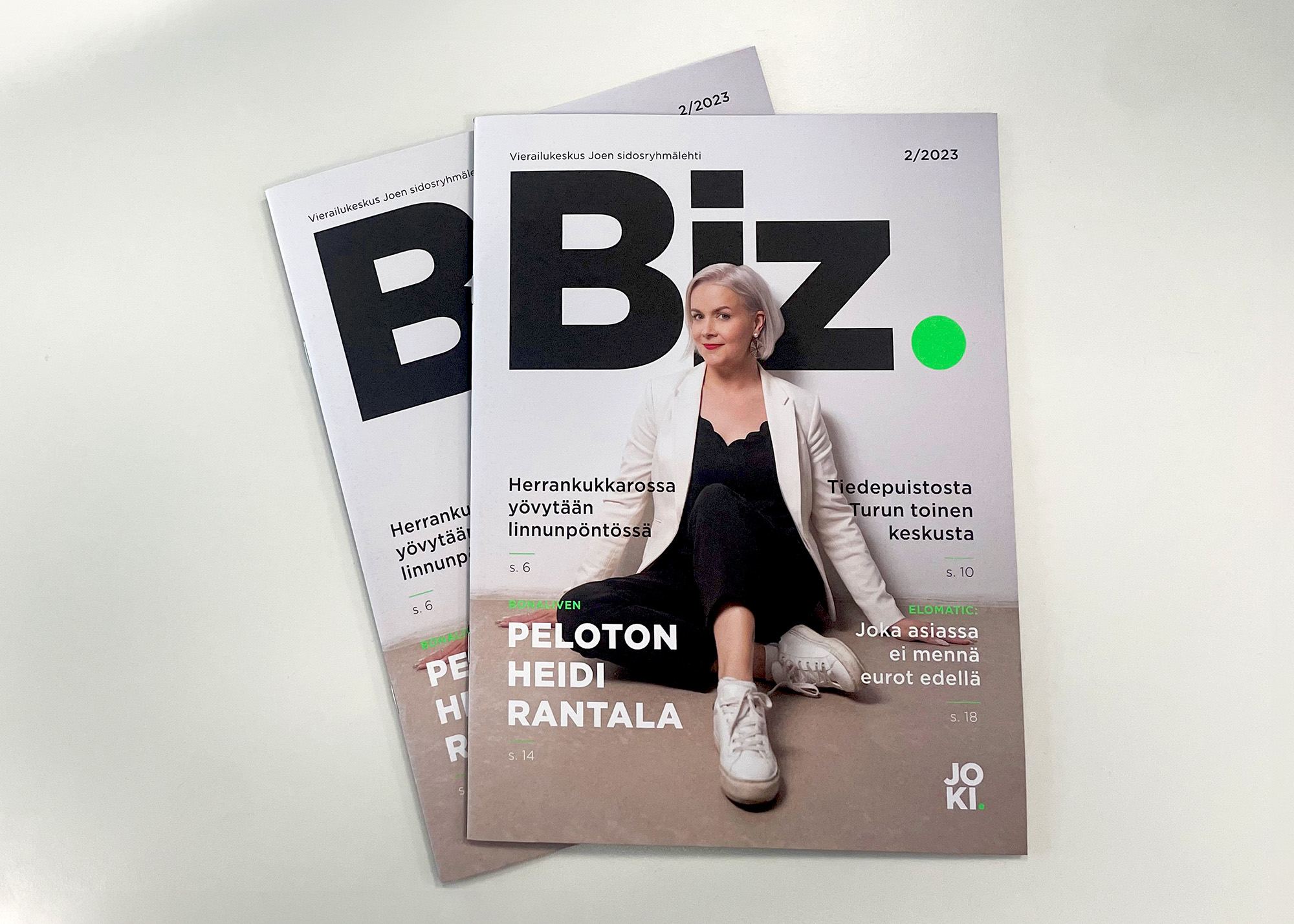 Kaksi Biz-lehteä päällekkäin, joiden kannessa poseeraa henkilö lattialla istuen